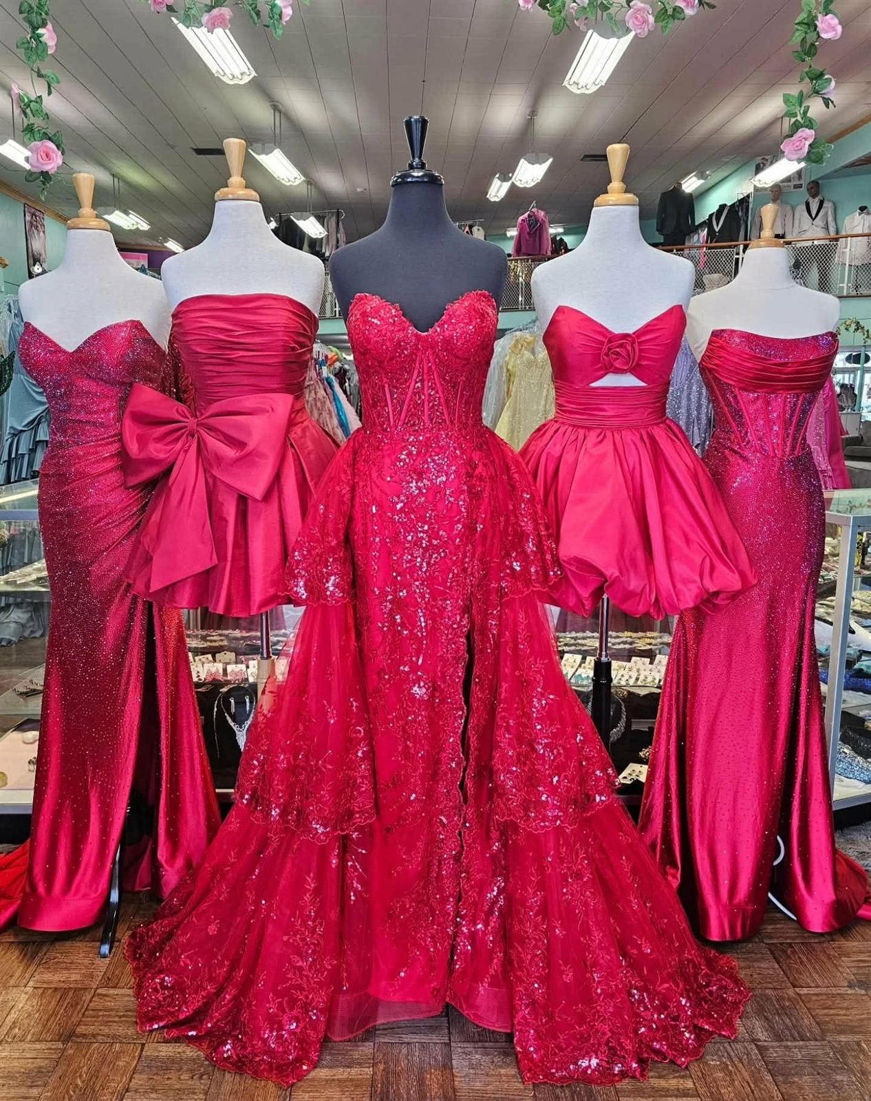 Rack of red and pink prom and pageant gowns in the boutique